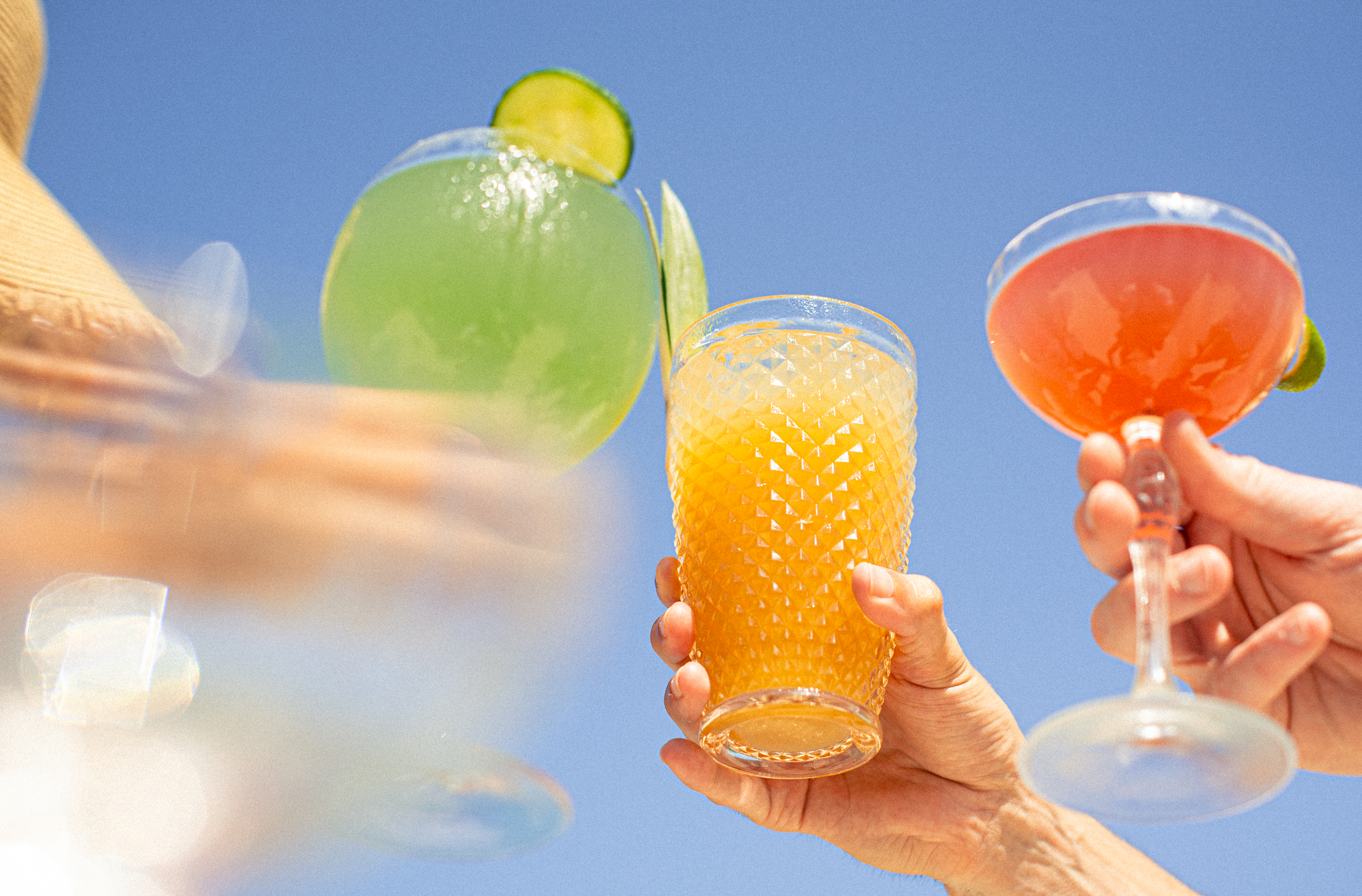 Verres de cocktails colorés réalisés par la machine à cocktails et levés en terrasse ensoleillée